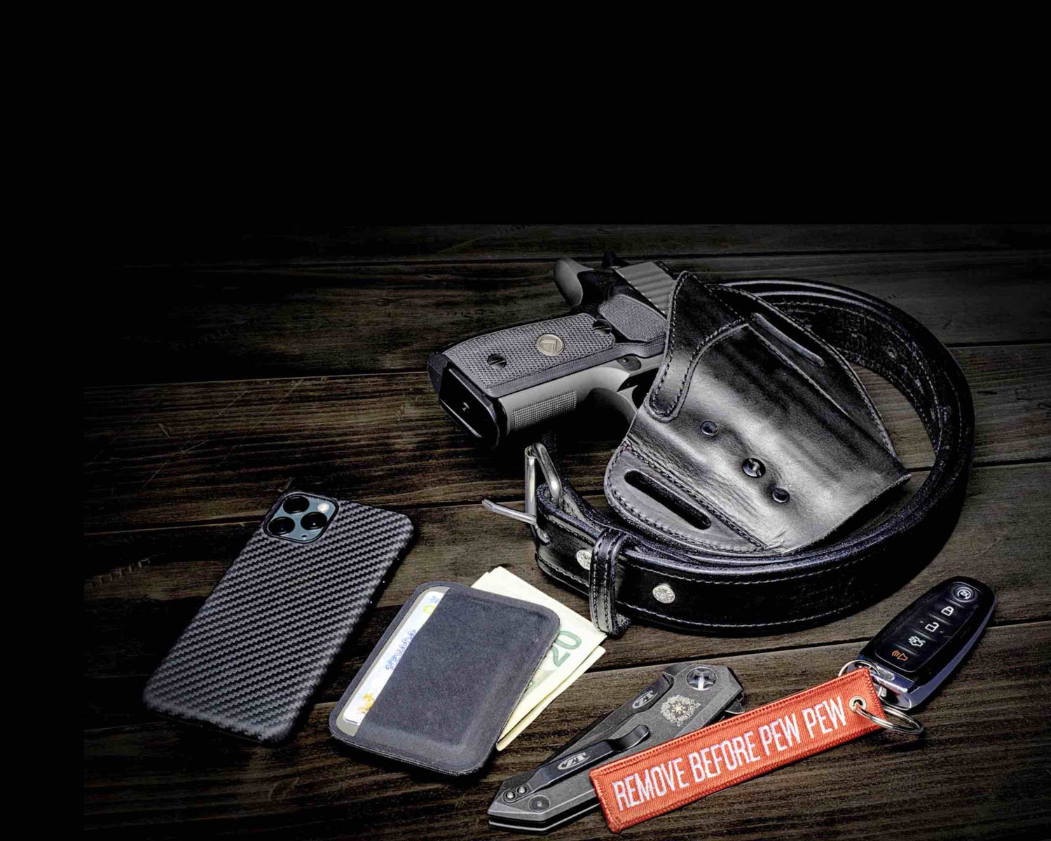 Urban carry holster, phone, wallet, knife sitting on a counter