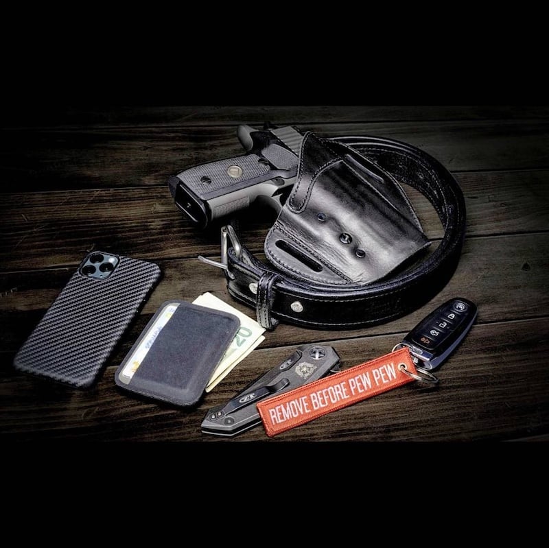 Urban carry holster, phone, wallet, knife sitting on a counter
