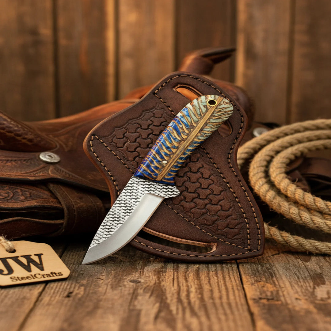 Knife with decorative handle on brown leather sheath next to rope on wooden surface