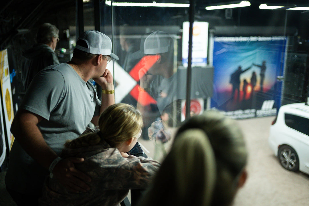 People inside a vehicle looking out at a scenic display with a bridge.