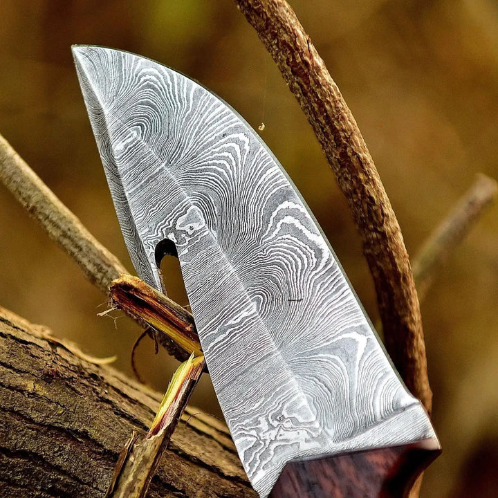 Decorative knife with a patterned blade on a wooden background